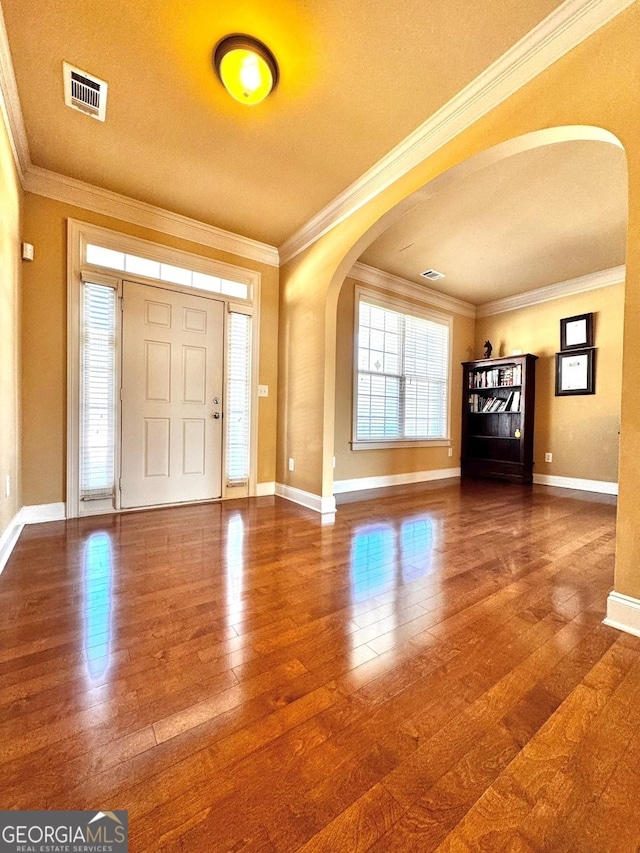 foyer with hardwood / wood-style flooring, crown molding, and a healthy amount of sunlight