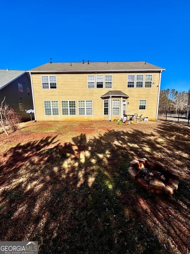 rear view of house with an outdoor fire pit