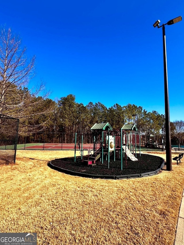 view of jungle gym with tennis court