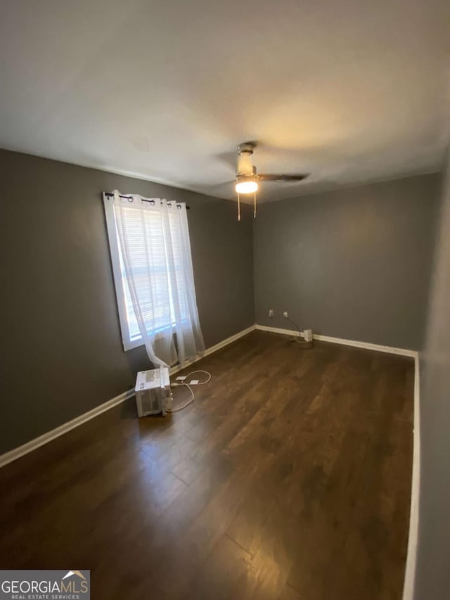 spare room featuring dark hardwood / wood-style floors and ceiling fan