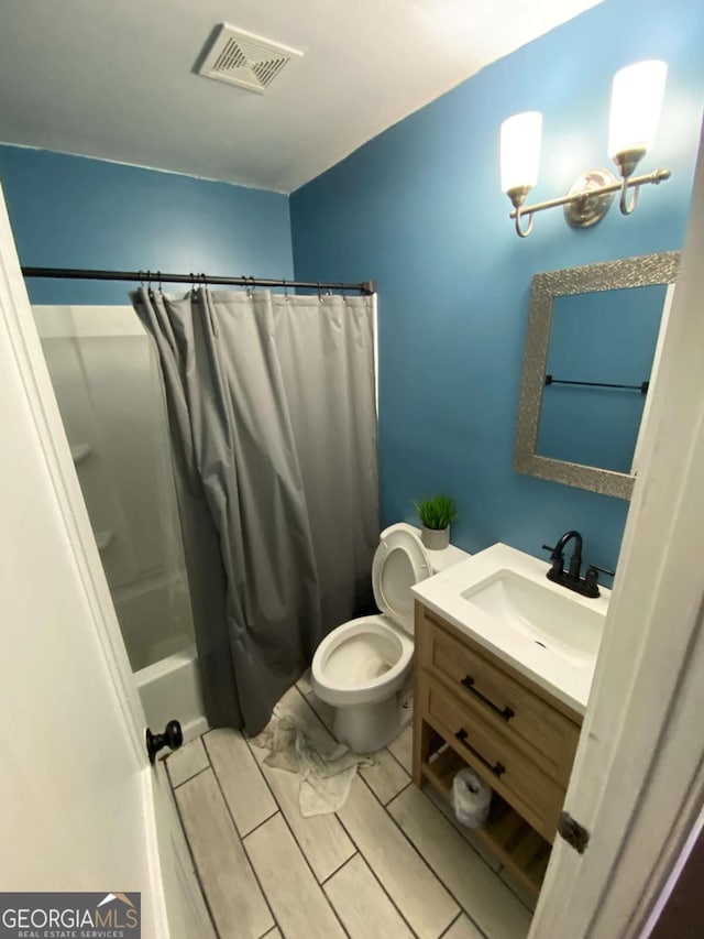 full bathroom with vanity, shower / bath combo, and toilet