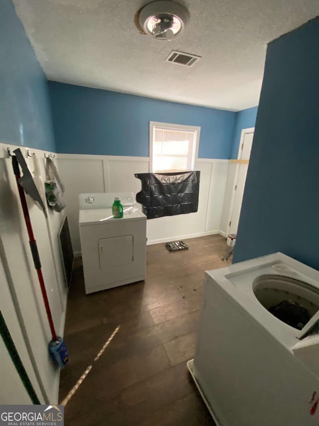 laundry room with separate washer and dryer and a textured ceiling