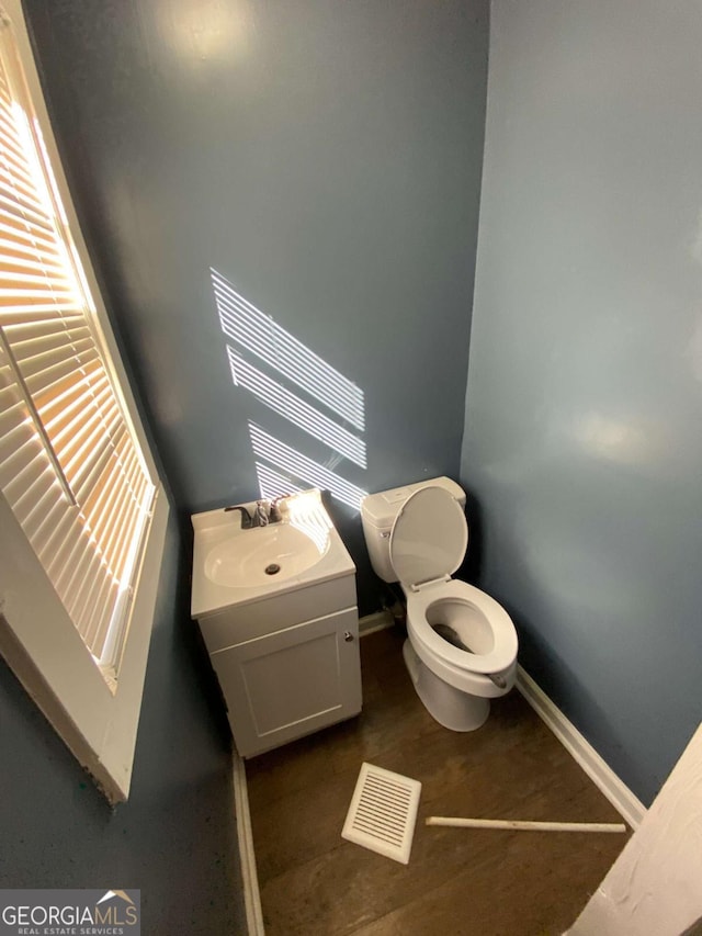 bathroom with vanity, toilet, and plenty of natural light