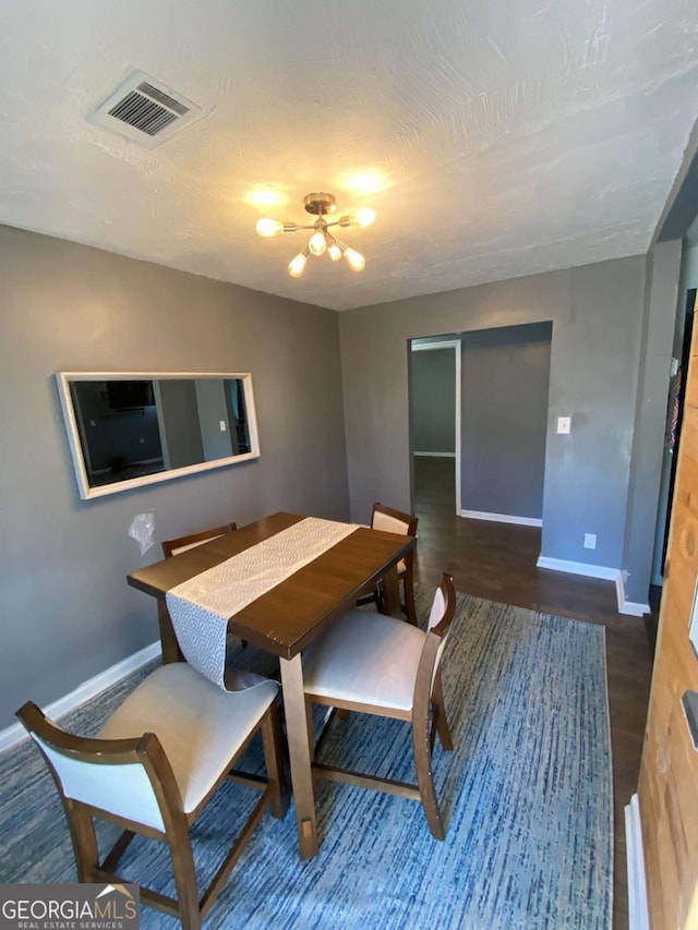 dining area featuring a textured ceiling and dark hardwood / wood-style flooring