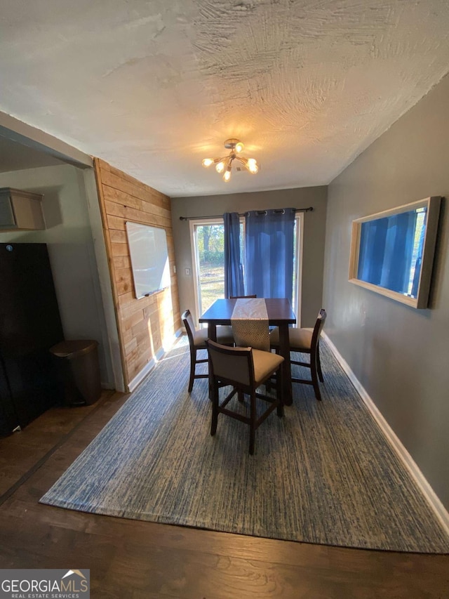 dining space featuring an inviting chandelier, dark hardwood / wood-style floors, and a textured ceiling