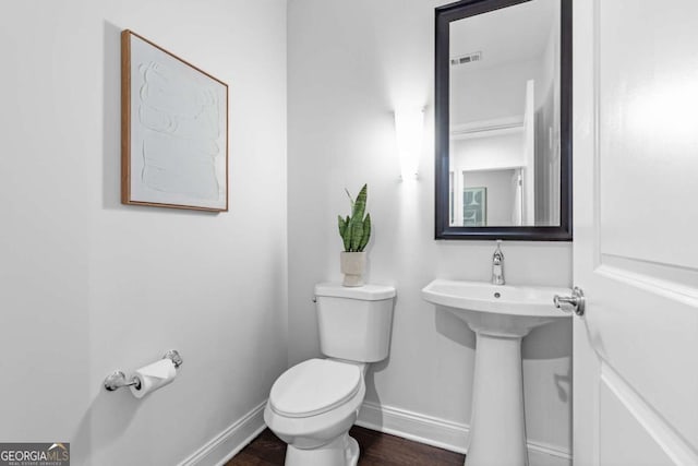 bathroom featuring wood-type flooring, toilet, and sink