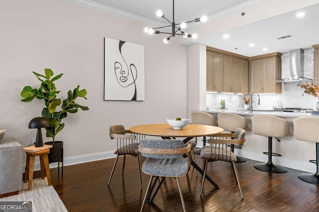 dining space featuring crown molding, dark wood-type flooring, and sink