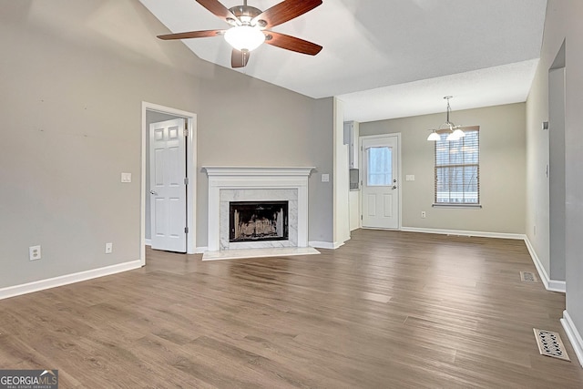 unfurnished living room with ceiling fan, a fireplace, and wood-type flooring