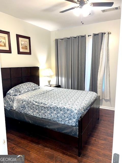 bedroom with ceiling fan and dark hardwood / wood-style flooring