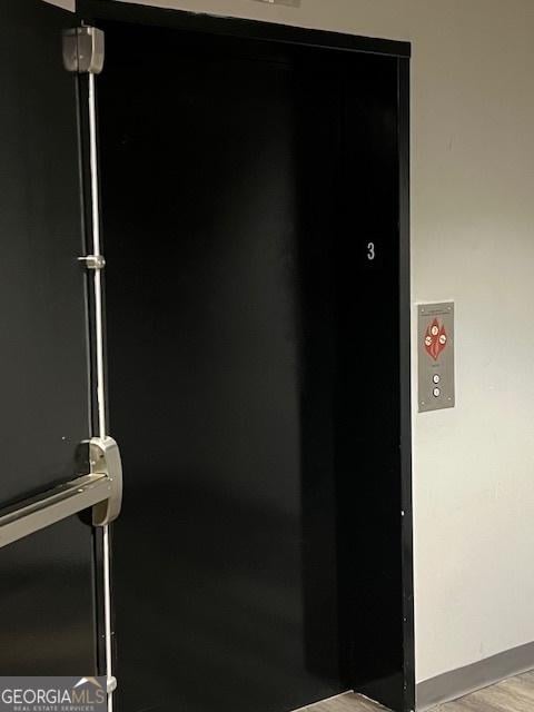 interior details featuring elevator and hardwood / wood-style floors