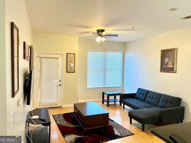 living room with ceiling fan and light hardwood / wood-style floors