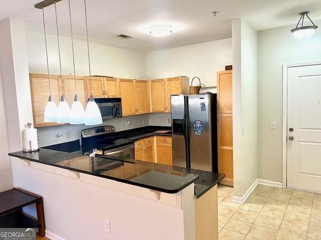 kitchen with pendant lighting, stainless steel appliances, kitchen peninsula, and a kitchen bar