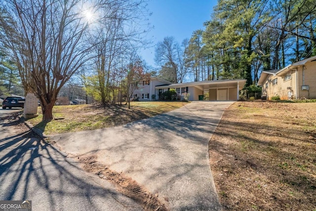 ranch-style home featuring a carport and a front lawn