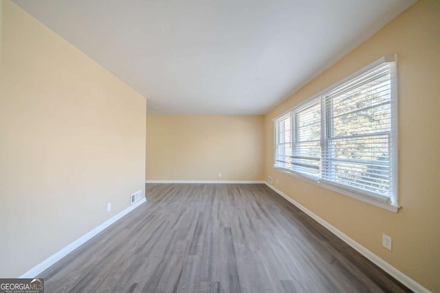 unfurnished room with dark wood-type flooring