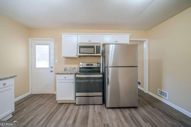 kitchen with appliances with stainless steel finishes, white cabinets, and dark hardwood / wood-style flooring