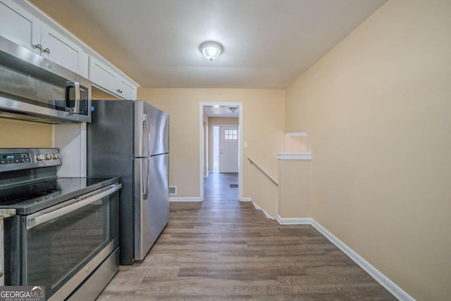 kitchen featuring stainless steel appliances, wood-type flooring, and white cabinets