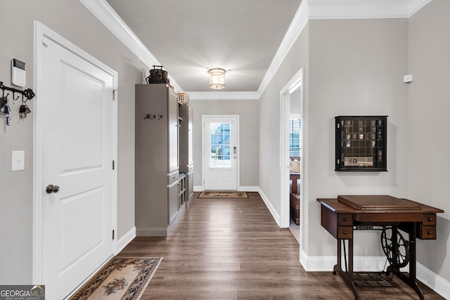 foyer entrance with ornamental molding and dark hardwood / wood-style floors