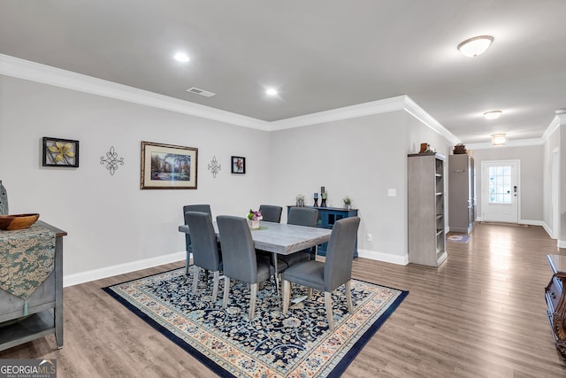 dining space with ornamental molding and wood-type flooring