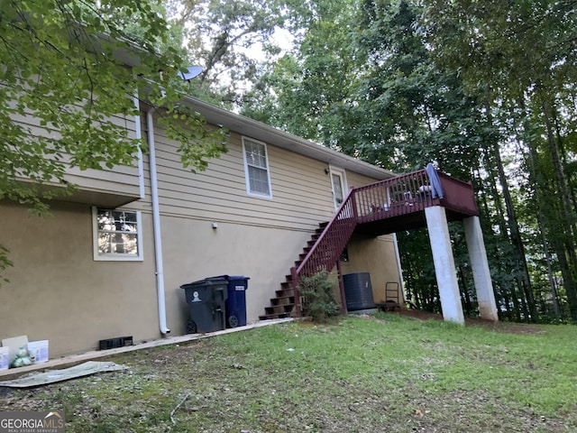 back of house featuring a wooden deck and a yard