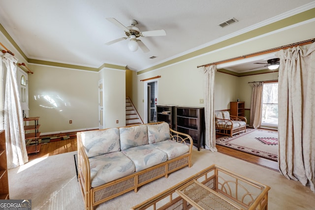 living room featuring crown molding, light hardwood / wood-style flooring, and ceiling fan