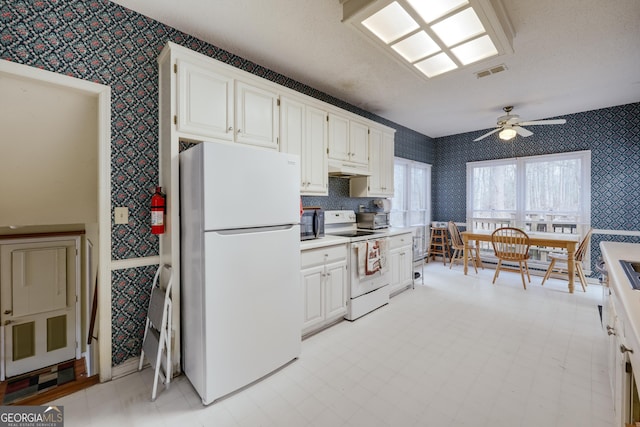 kitchen featuring ceiling fan, a textured ceiling, white cabinets, and white appliances