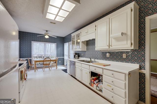 kitchen featuring sink, white appliances, a textured ceiling, and ceiling fan