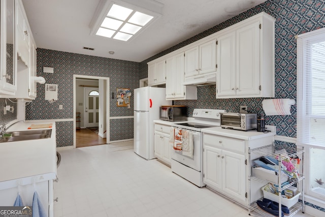 kitchen with white cabinetry, sink, and white appliances