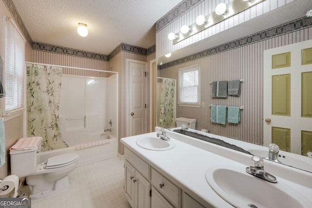 full bathroom with vanity, shower / bathtub combination with curtain, a textured ceiling, and toilet