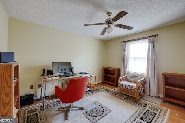 office area with ceiling fan, hardwood / wood-style floors, and a textured ceiling