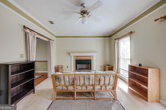 carpeted bedroom with ceiling fan, crown molding, and a textured ceiling