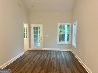 unfurnished room featuring dark hardwood / wood-style floors and high vaulted ceiling