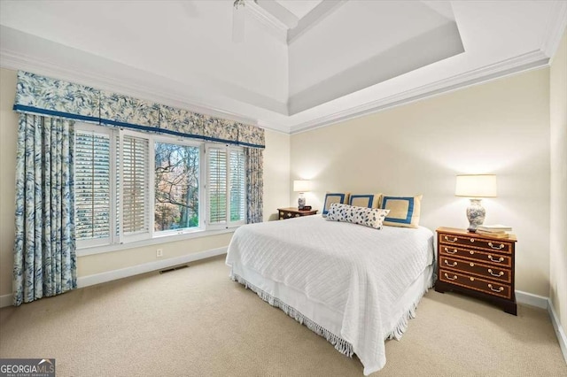 bedroom with a tray ceiling, ornamental molding, and carpet flooring