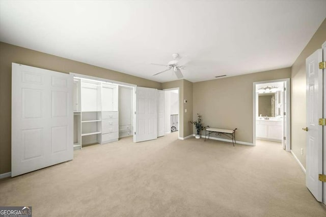 unfurnished bedroom with ceiling fan, light carpet, and ensuite bath