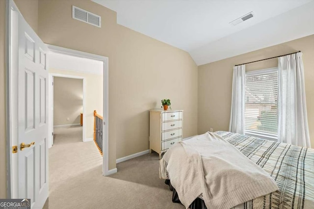 bedroom featuring lofted ceiling and light carpet