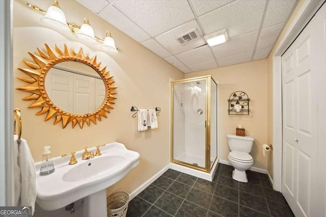 bathroom with walk in shower, a paneled ceiling, toilet, and sink