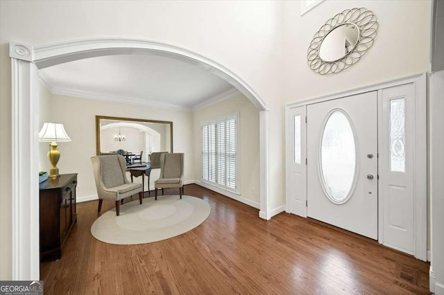 entryway with ornamental molding and hardwood / wood-style floors