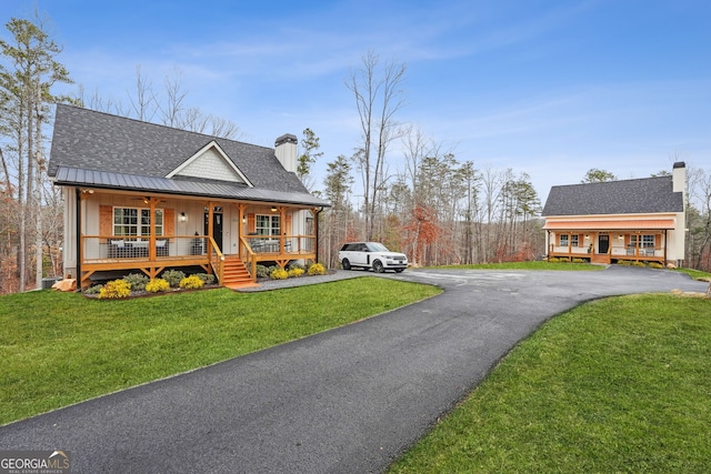 view of front of house featuring covered porch and a front yard