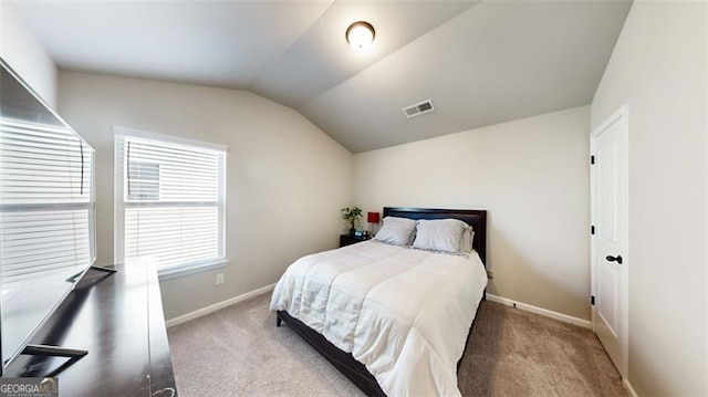 carpeted bedroom with lofted ceiling