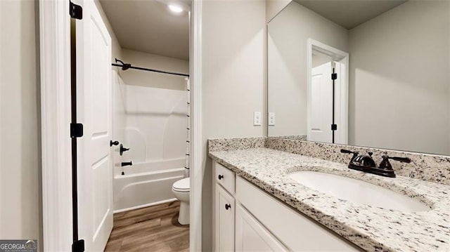 full bathroom with vanity, hardwood / wood-style floors, toilet, and shower / bath combination