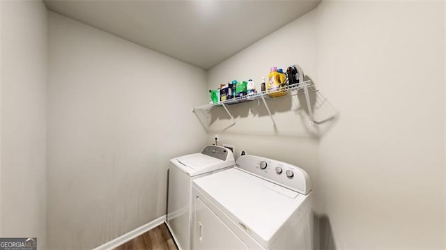 laundry room with hardwood / wood-style flooring and washer and dryer