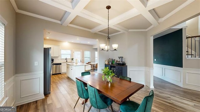 dining room with sink, crown molding, an inviting chandelier, beam ceiling, and light hardwood / wood-style floors