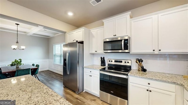 kitchen with coffered ceiling, light stone counters, stainless steel appliances, beam ceiling, and white cabinets