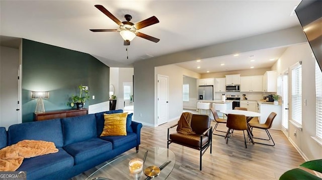 living room with ceiling fan and light hardwood / wood-style flooring