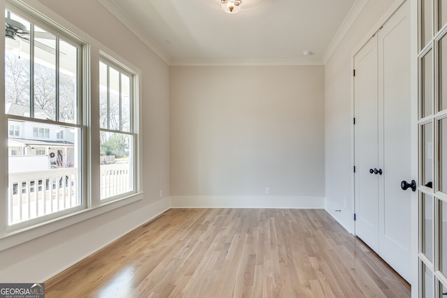 spare room featuring crown molding and light hardwood / wood-style floors