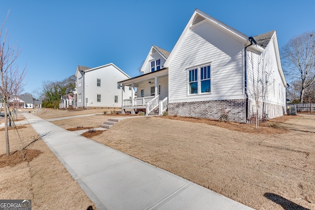 view of front facade with cooling unit, covered porch, and a front lawn