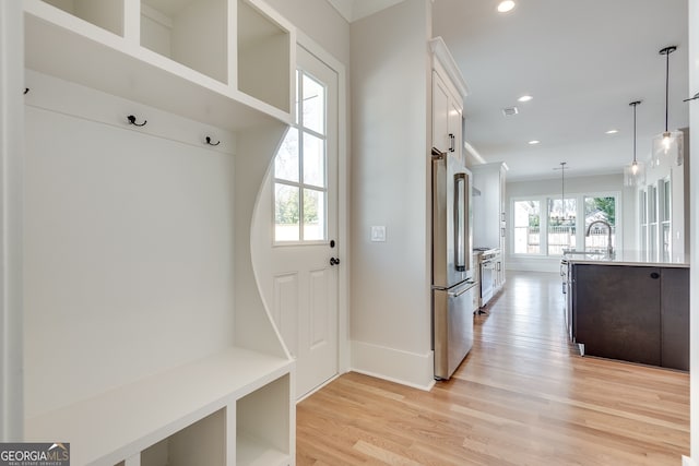 mudroom with an inviting chandelier and light hardwood / wood-style flooring