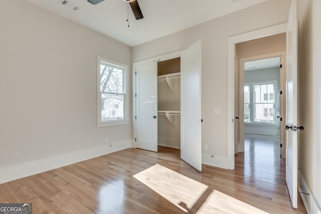 unfurnished bedroom featuring light wood-type flooring, ceiling fan, and a closet