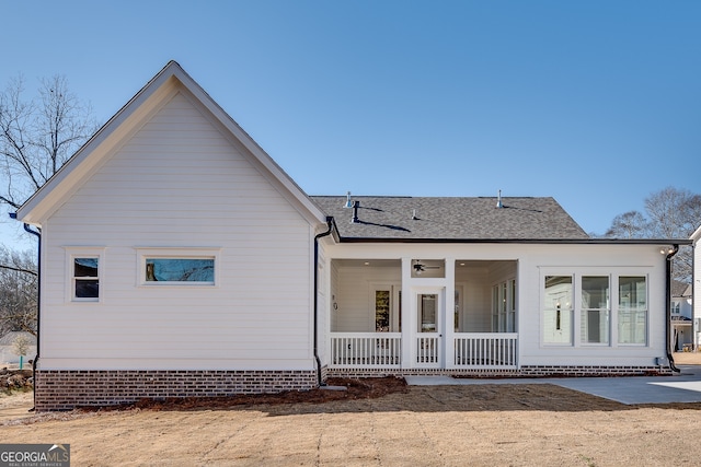 back of house with ceiling fan and a porch