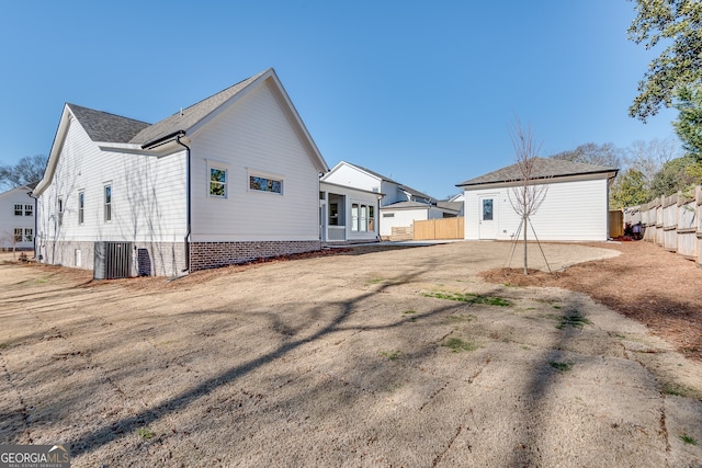 rear view of property with central AC