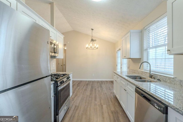 kitchen with stainless steel appliances, sink, and white cabinets